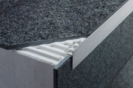 Schluter® SCHIENE-STEP profile covers sub-assembly of countertops, stairs, and existing wall tile